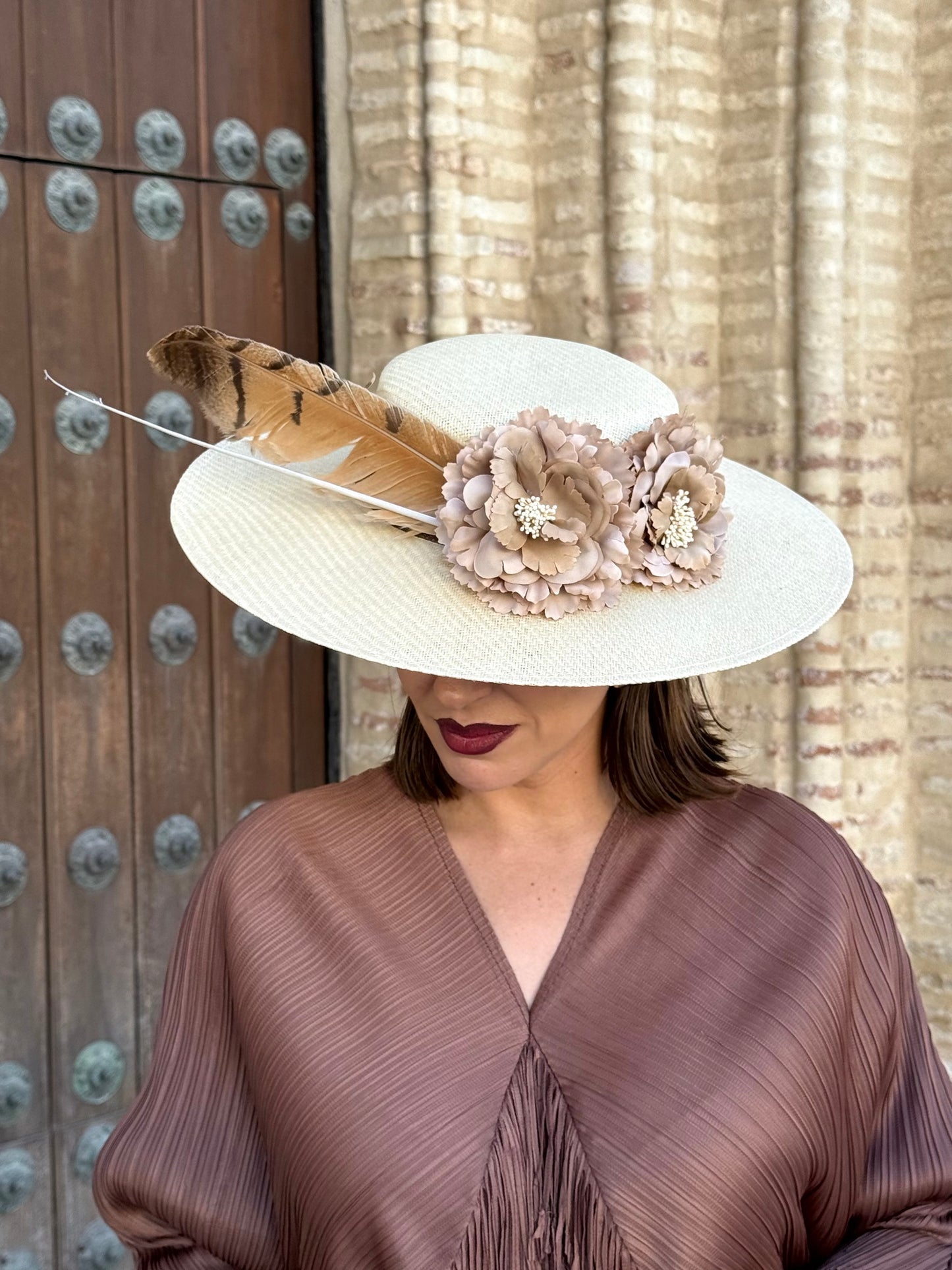 Pamela de invitada con flores y plumas