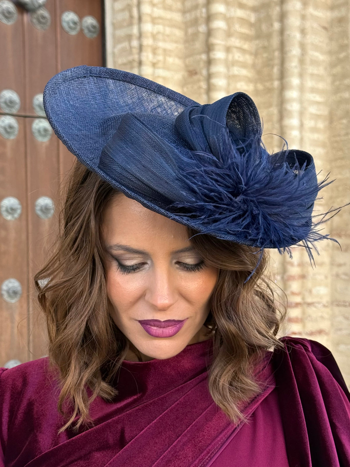 Tocado azul marino con lazada y plumas