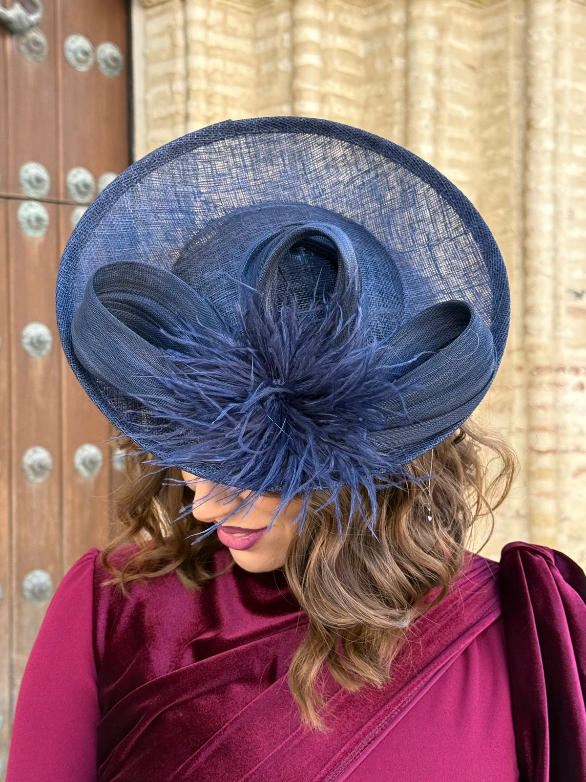 Tocado azul marino con lazada y plumas