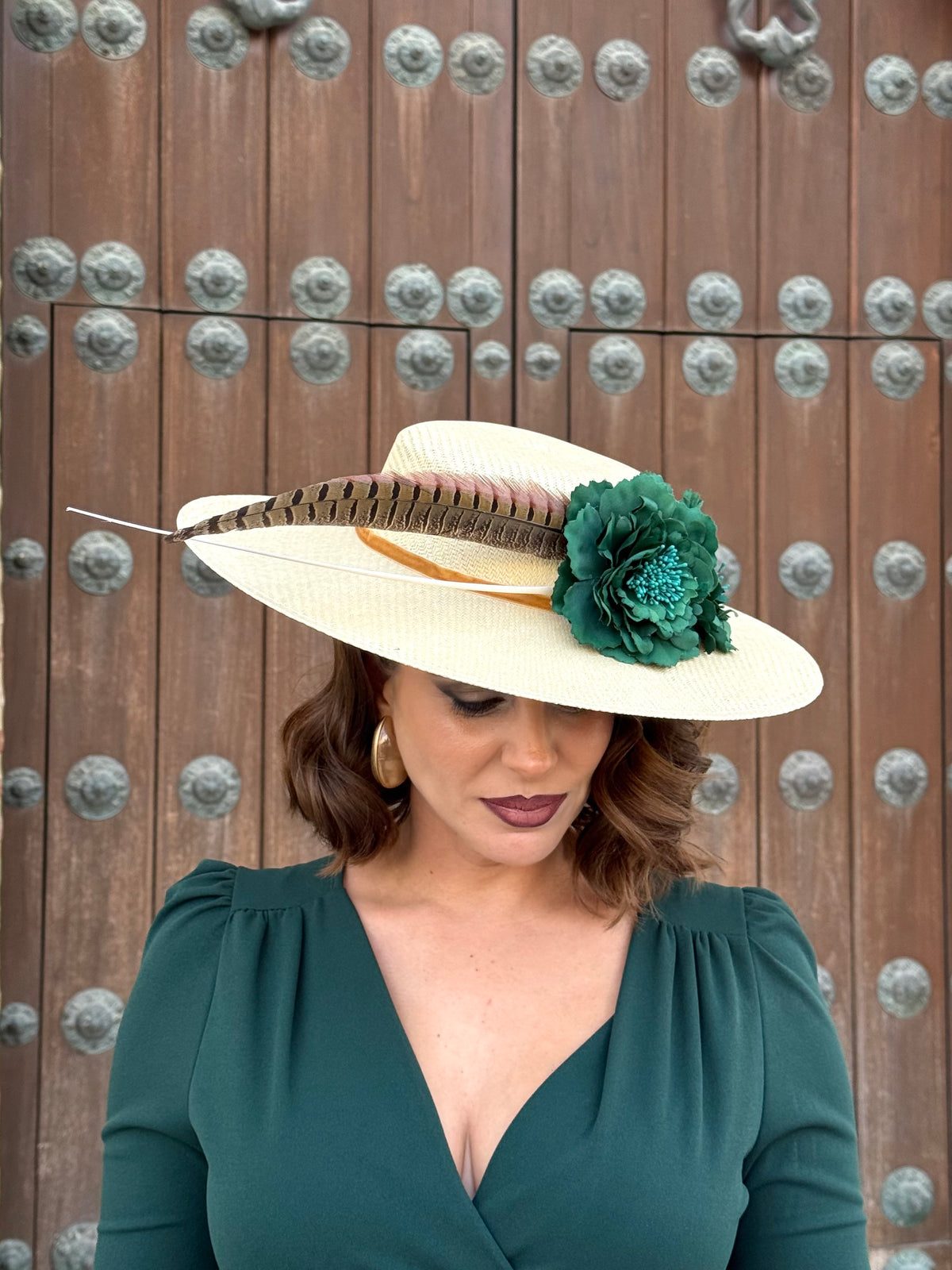 Pamela de invitada con flores Verdes y plumas