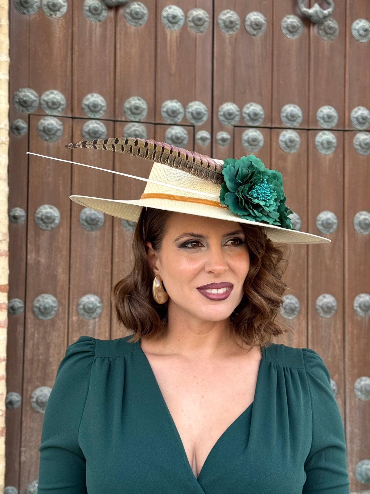 Pamela de invitada con flores Verdes y plumas