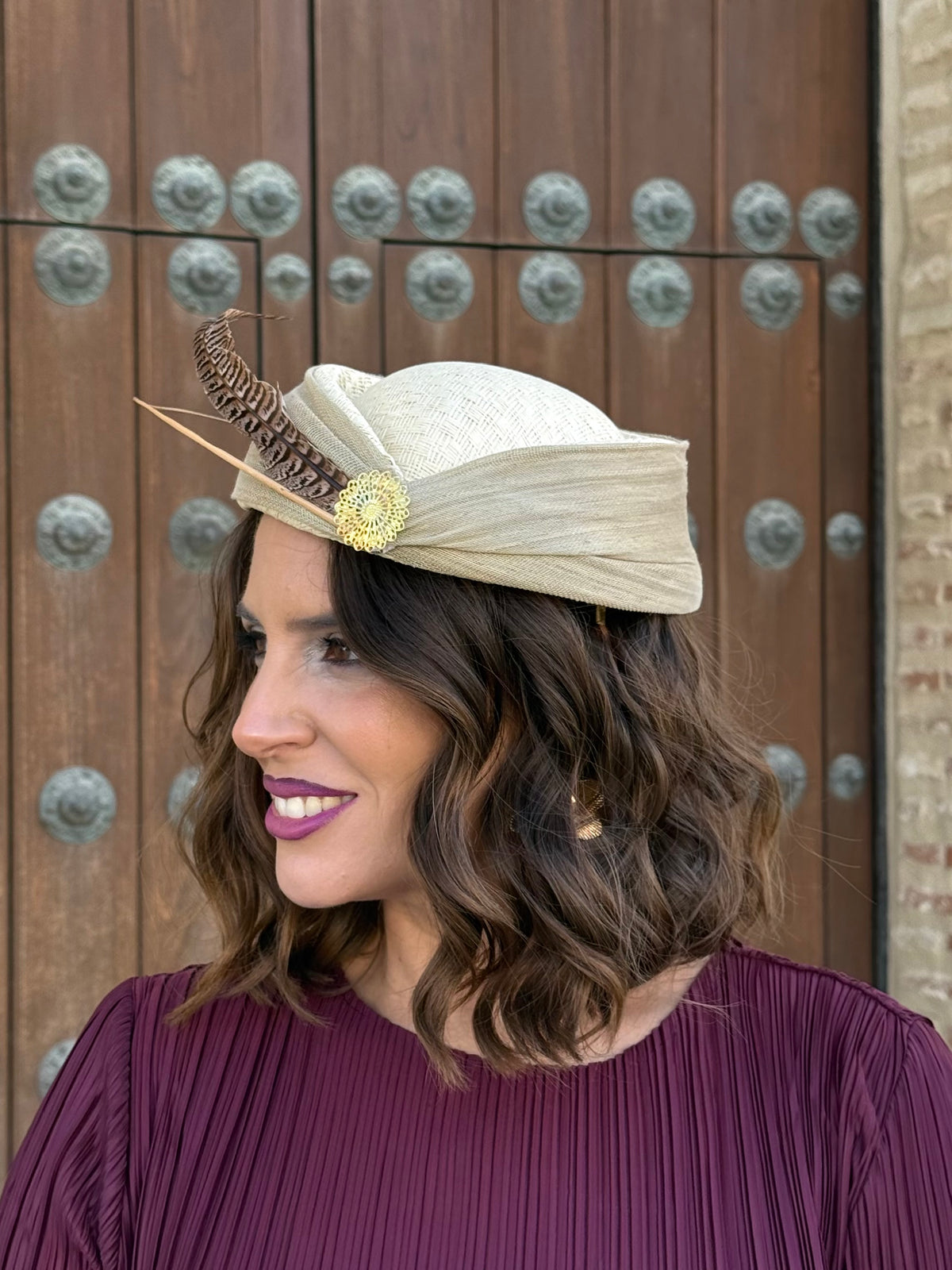 Tocado Inés tipo casquete beige con pluma y adorno dorado