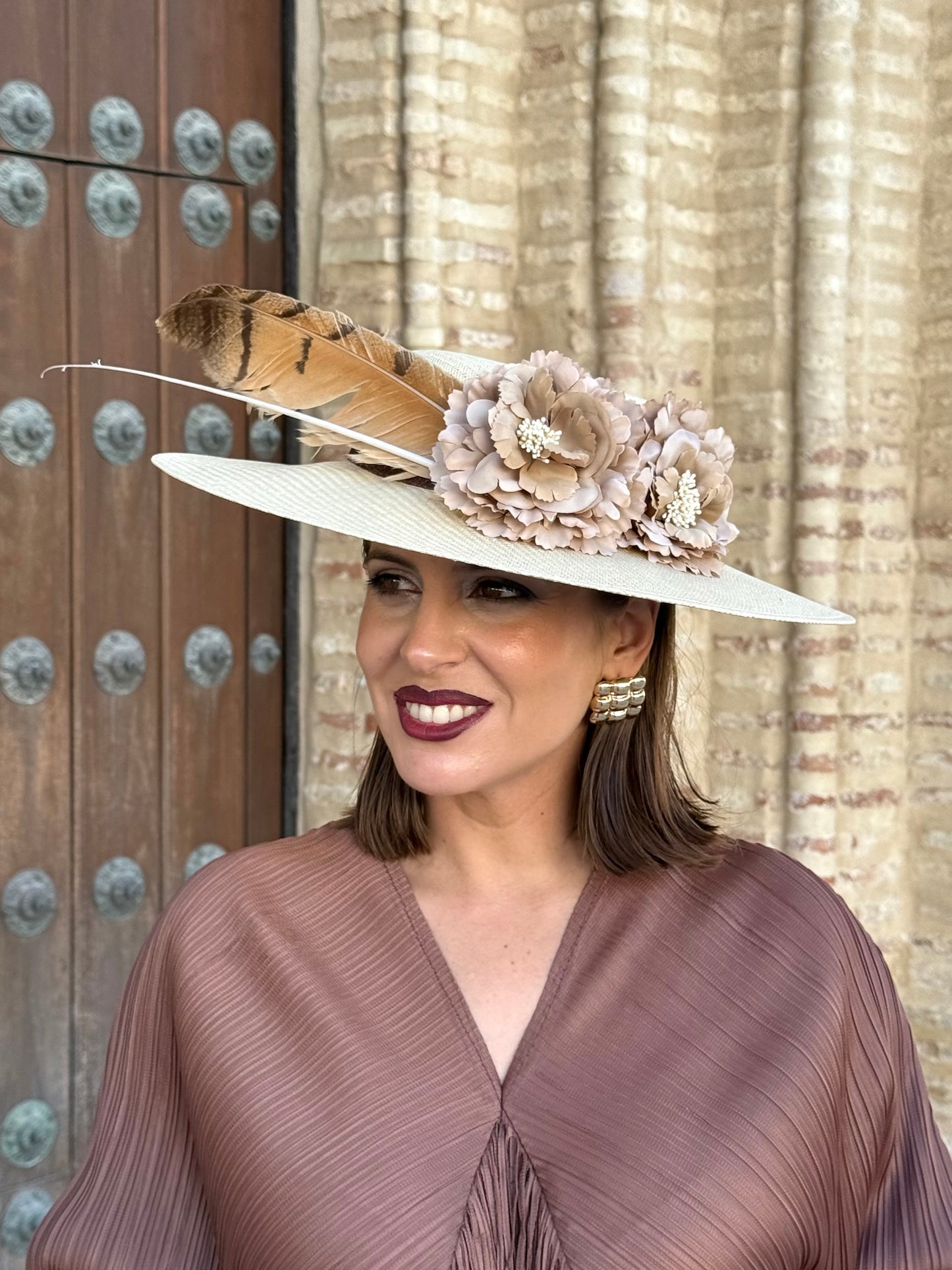 Pamela de invitada con flores y plumas