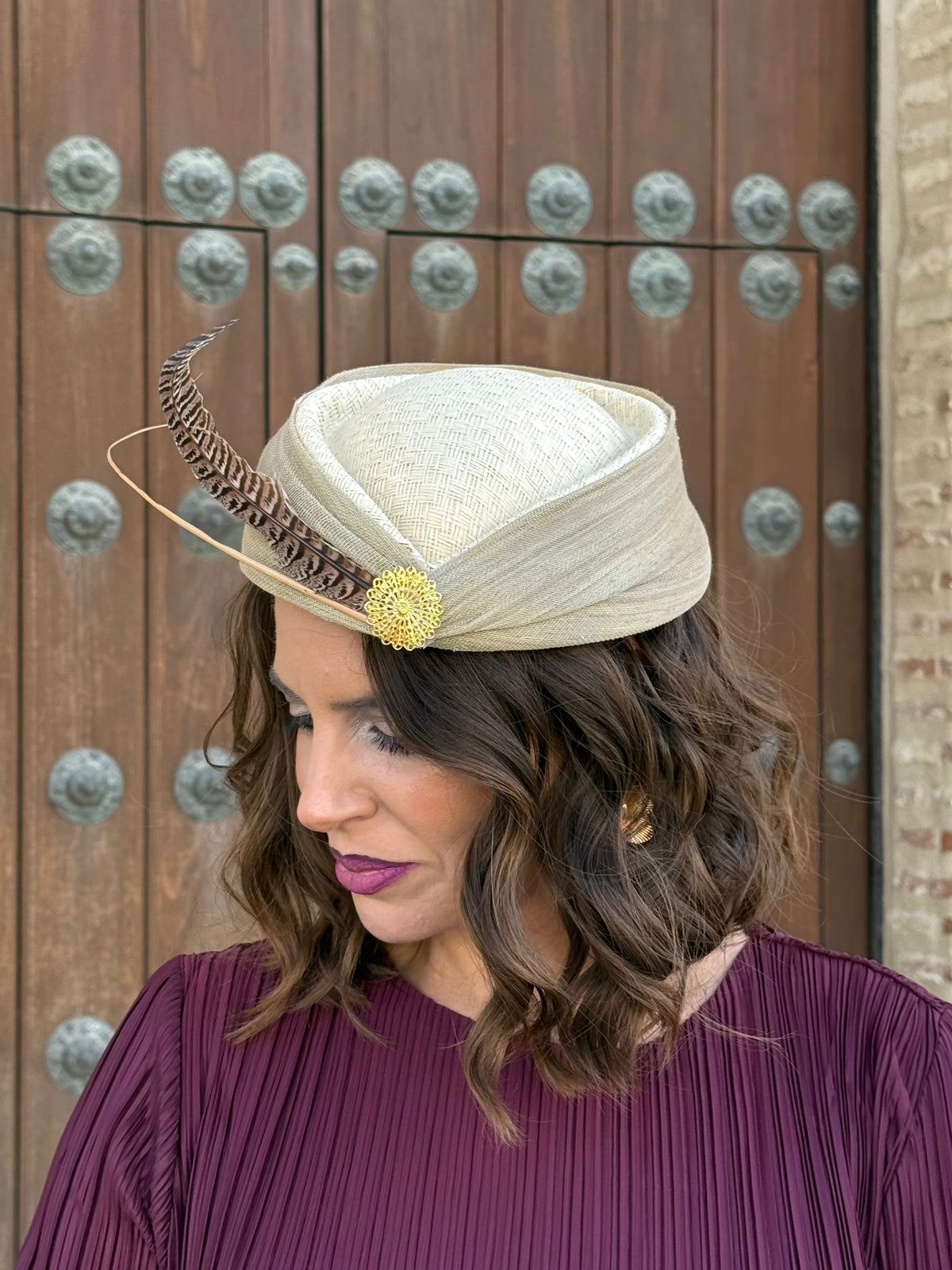 Tocado Inés tipo casquete beige con pluma y adorno dorado