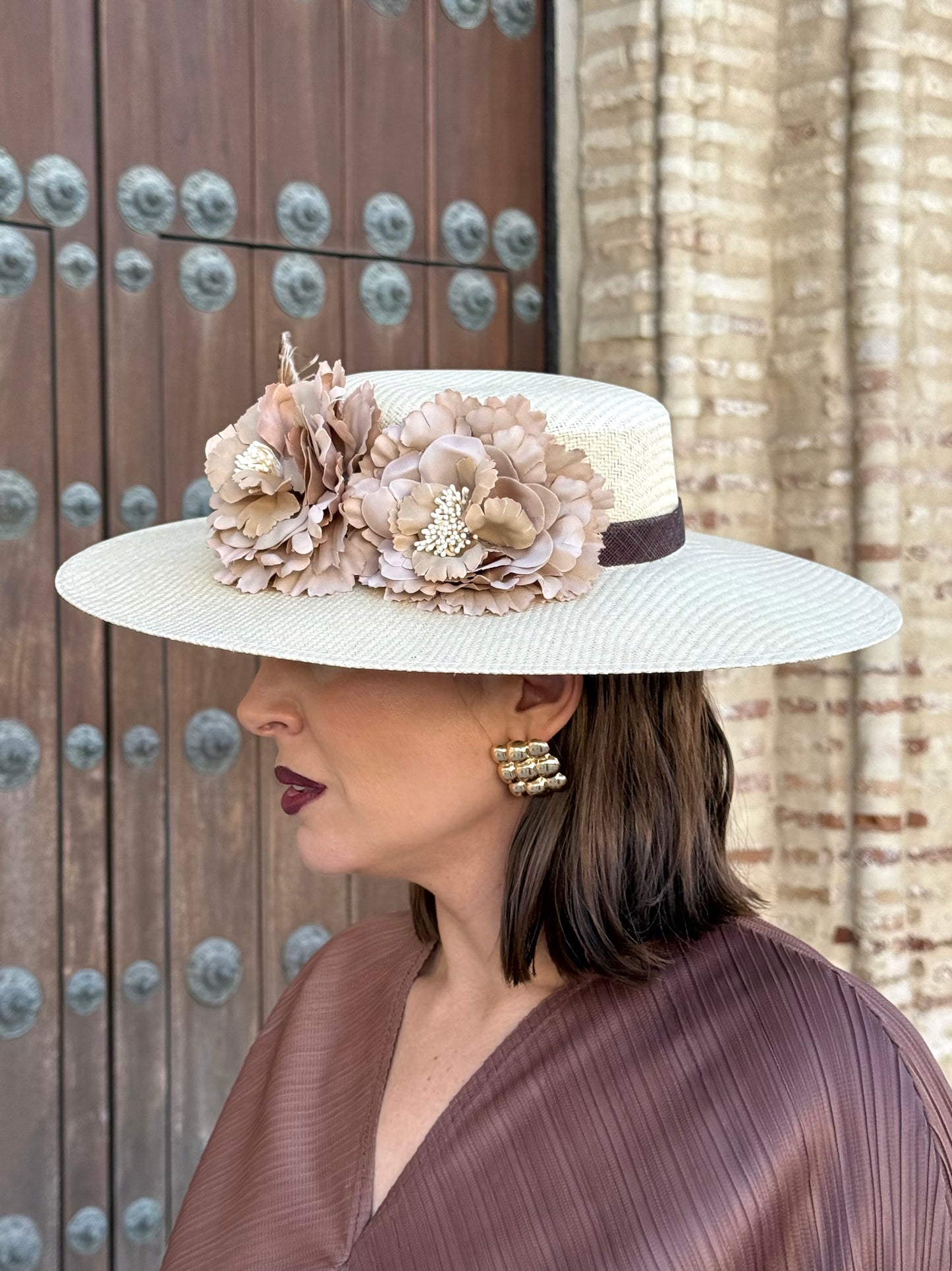 Pamela de invitada con flores y plumas