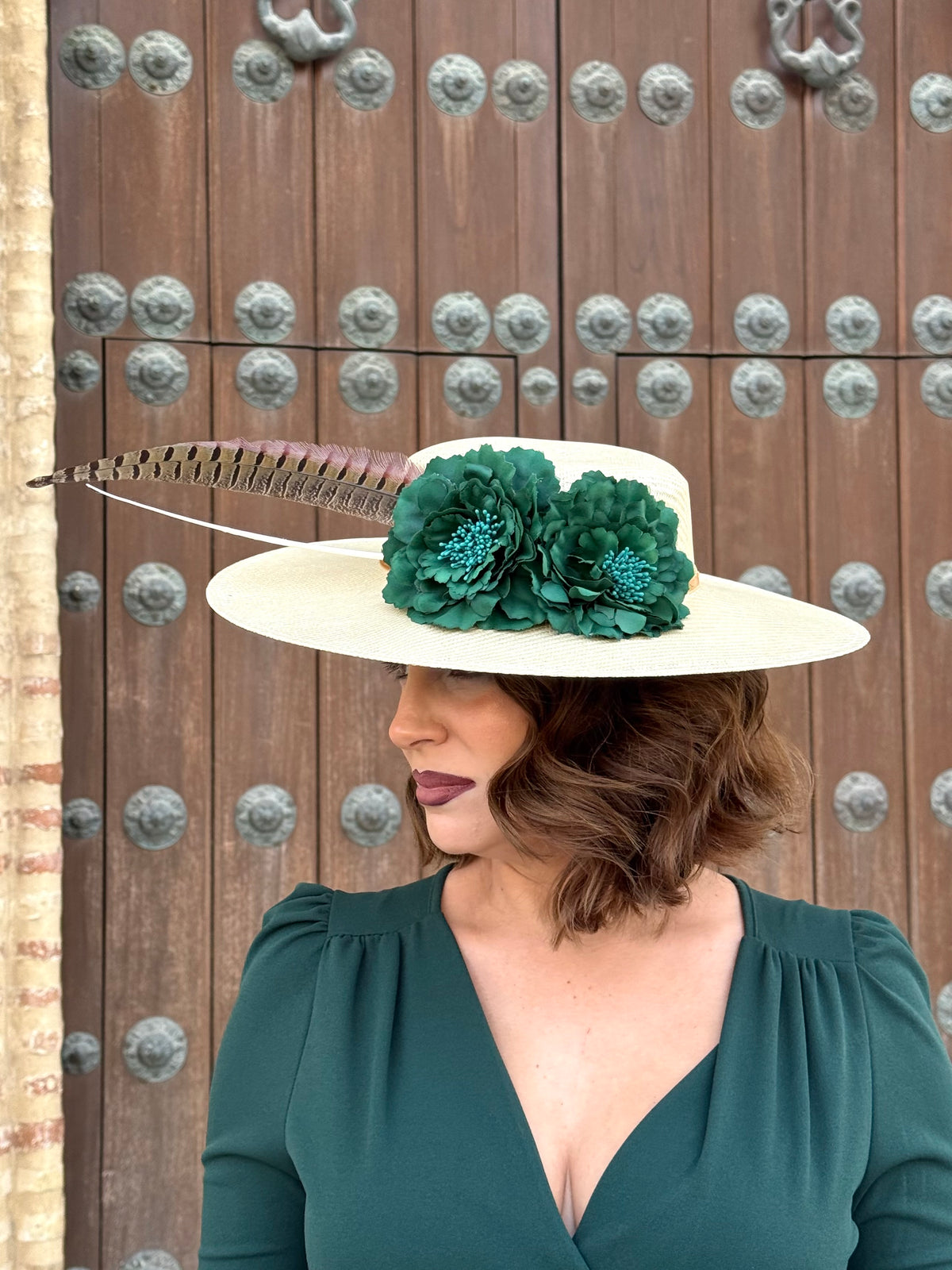 Pamela de invitada con flores Verdes y plumas